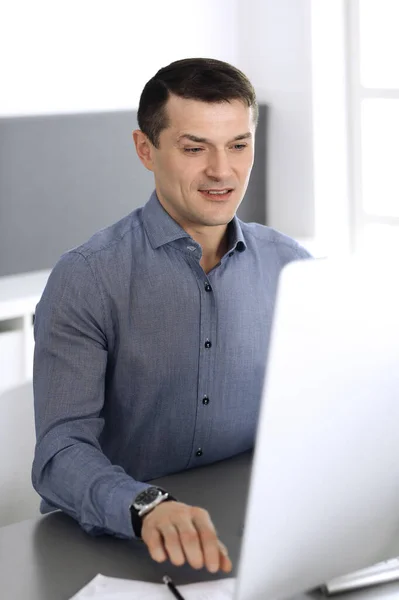 Бизнесмен, работающий с компьютером в современном офисе. Фото мужчины-предпринимателя или директора компании на рабочем месте. Концепция бизнеса — стоковое фото