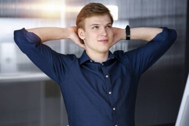 Genç sarışın işadamı ve programcı karanlık bir ofiste bilgisayarla sıkı çalıştıktan sonra el ele tutuşuyor, arka planda ışık parlıyor.