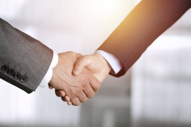 Güneşli ofiste el sıkışan iş adamları, yakın plan. El sıkışma ve pazarlama