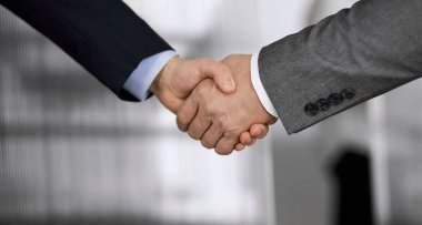 Ofisteki iş adamları ayakta ve el sıkışıyorlar, yakın plan. İş iletişimi kavramı. El sıkışma ve pazarlama