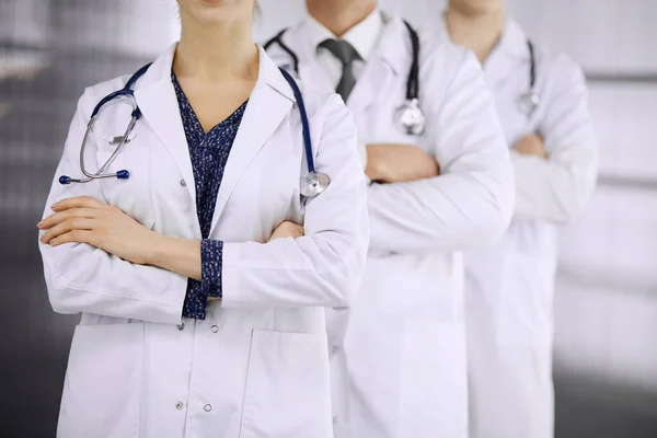 Médicos de pie como un equipo con los brazos cruzados en la clínica. Ayuda médica, seguro y concepto de medicina —  Fotos de Stock