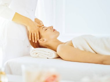 Güneşli spa merkezinde yüz masajından hoşlanan güzel bir kadın. Tıpta rahatlatıcı tedavi kavramı
