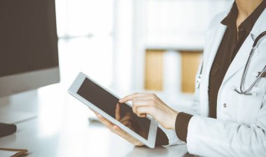 Klinikte tablet bilgisayar kullanan kimliği belirsiz kadın doktor. Hastanede mükemmel bir tıbbi hizmet. Tıp konsepti