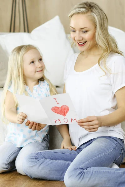 Glücklicher Muttertag. Die Tochter gratuliert der Mutter und überreicht ihr eine Postkarte mit Herzzeichnung. Familien- und Kindheitskonzepte — Stockfoto