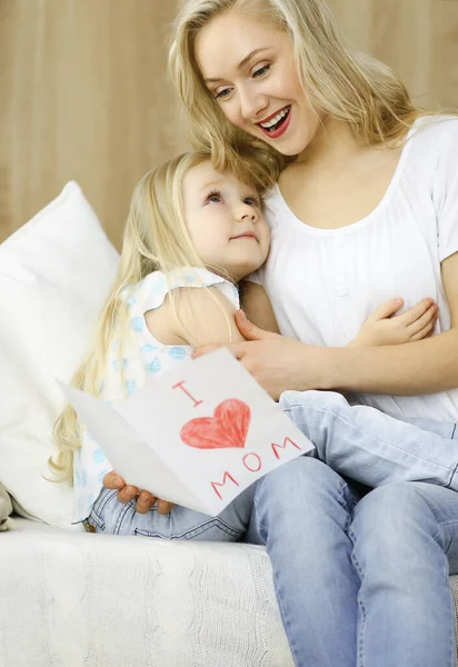 Bonne fête des mères. Enfant fille félicite maman et donne sa carte postale avec le dessin du cœur. Concepts famille et enfance — Photo