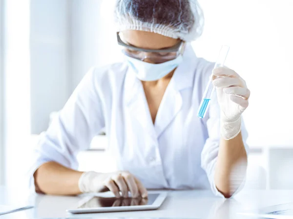 Cientista profissional em óculos de proteção pesquisando tubo com reagentes em laboratório. Conceitos de medicina e pesquisa científica — Fotografia de Stock