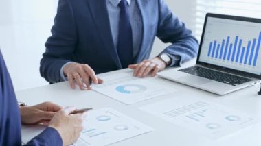İş arkadaşları finansal verileri inceliyor, grafikleri ve grafikleri analiz ediyor, ortak toplantı sırasında dizüstü bilgisayarın ekranına işaret ediyorlar. İş adamları ve finans kavramı.