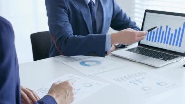 Bir dizüstü bilgisayarda finansal verileri tartışan çok sayıda iş arkadaşından oluşan bir ekip, görevdeki grafikleri ve pazar eğilimlerini analiz ediyor. İş adamları ve finans kavramı.