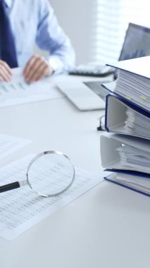 Muhasebeciler mali raporları büyüteç ve belgelerle inceliyor, muhasebe ve denetleme görevlerini yerine getiriyor, kapatın. Ticarette denetim ve vergiler.