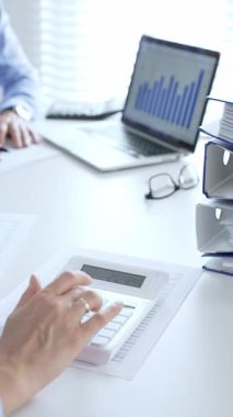 Finans uzmanları evrakları inceliyor, verileri analiz ediyor ve takım toplantılarında mali stratejileri tartışıyor. İş dünyasında denetim ve vergi teması