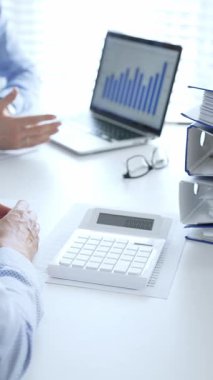 Finans uzmanları evrakları inceliyor, verileri analiz ediyor ve takım toplantılarında mali stratejileri tartışıyor. İş dünyasında denetim ve vergi teması