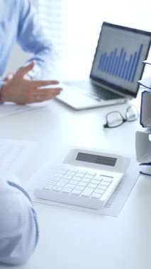 Finans uzmanları evrakları inceliyor, verileri analiz ediyor ve takım toplantılarında mali stratejileri tartışıyor. İş dünyasında denetim ve vergi teması