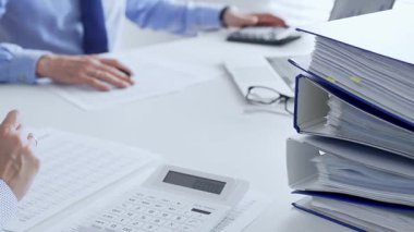 Finans uzmanları evrakları inceliyor, verileri analiz ediyor ve takım toplantılarında mali stratejileri tartışıyor. İş dünyasında denetim ve vergi teması