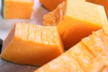 Tahta masada parçalara ayrılmış sarı balkabağı.