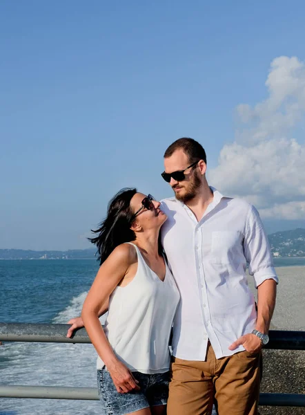 一对快乐的恋人在港口散步 微笑的男人和幸运的女人穿着白色的衣服 在外面的海滩上 — 图库照片
