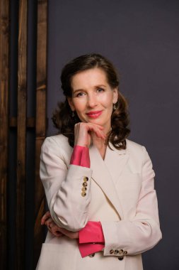 Beyaz takım elbiseli zarif bir iş kadını. Psikoterapist yaşam tarzı. Kadın portresi. Gri arkaplan.