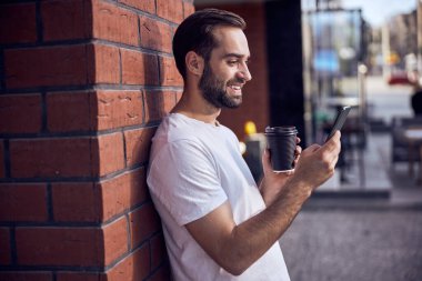 Akıllı telefon arayan kahveli eğlenceli adam.