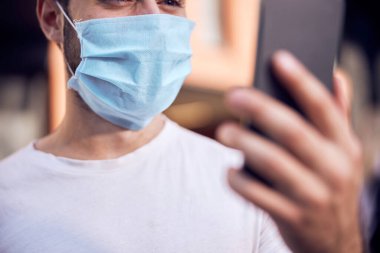 Akıllı telefonlu maskeli adam. 