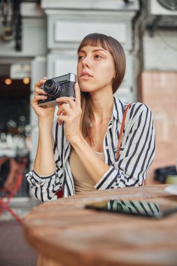 Düşüncelere dalmış genç kadın fotoğrafçının belini kaldırın.