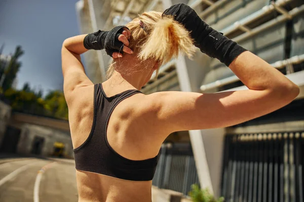 Vista Trasera Una Hermosa Mujer Deportiva Deportiva Alisándose Cabello Mientras —  Fotos de Stock