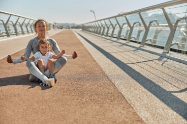 Mutlu sağlıklı ve sportif anne ve kızı güneşli bir günde antrenman yapıyor.