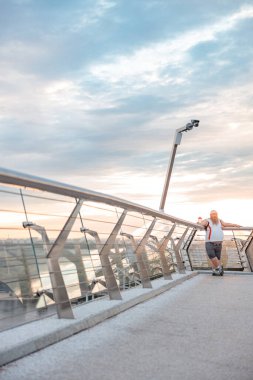 Şişman, beyaz sakallı ve cesur adam sabah egzersizleri yapıyor.