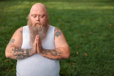 Şişman, beyaz sakallı ve cesur adam sabah egzersizleri yapıyor.