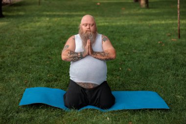 Şişman, beyaz sakallı ve cesur adam sabah egzersizleri yapıyor.