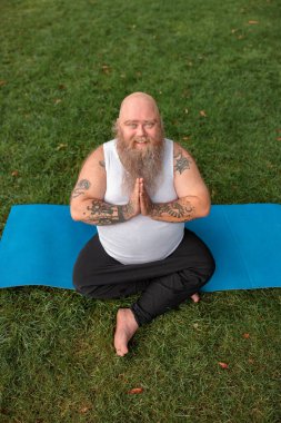 Şişman, beyaz sakallı ve cesur adam sabah egzersizleri yapıyor.