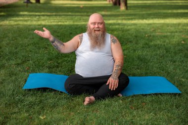 Şişman, beyaz sakallı ve cesur adam sabah egzersizleri yapıyor.