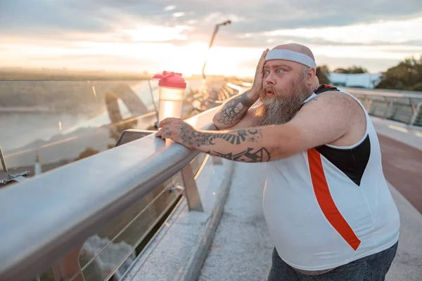 Şişman, beyaz sakallı ve cesur adam sabah egzersizleri yapıyor.