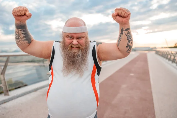 Fat caucasian bearded and bold man is doing morning exercses to loose his weight