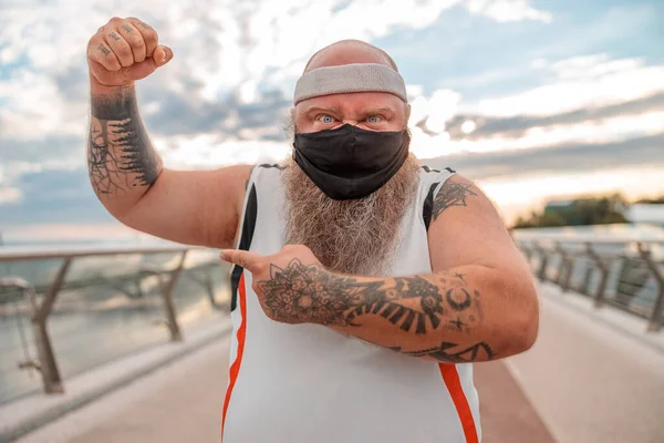 Fat caucasian bearded and bold man is doing morning exercses to loose his weight