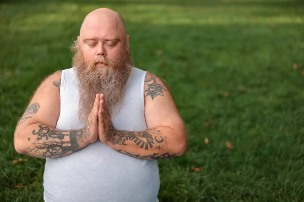 Şişman, beyaz sakallı ve cesur adam sabah egzersizleri yapıyor.