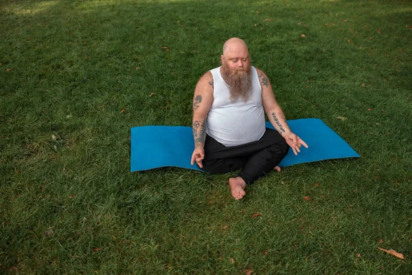 Fat caucasian bearded and bold man is doing morning exercses to loose his weight