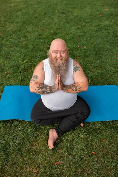 Şişman, beyaz sakallı ve cesur adam sabah egzersizleri yapıyor.