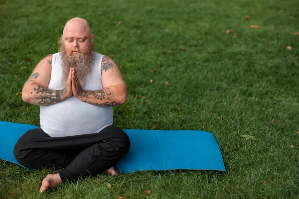 Fat caucasian bearded and bold man is doing morning exercses to loose his weight