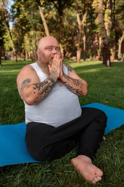 Fat caucasian bearded and bold man is doing morning exercses to loose his weight