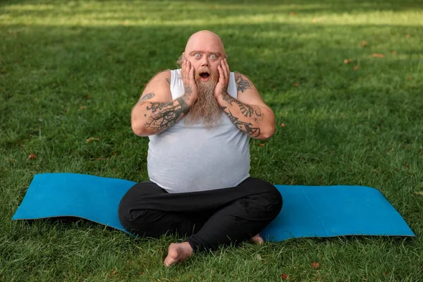 Fat caucasian bearded and bold man is doing morning exercses to loose his weight