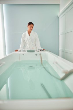 Güzel, sağlıklı, gülümseyen, beyaz bir kadın güzellik merkezinde güzellik prosedürleri uyguluyor.