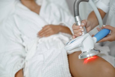 Güzel, sağlıklı, gülümseyen, beyaz bir kadın güzellik merkezinde güzellik prosedürleri uyguluyor.