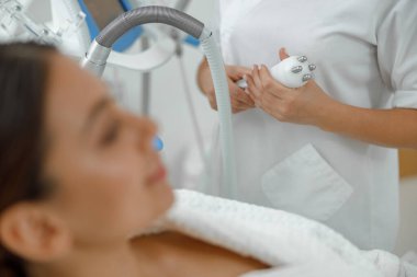 Güzel, sağlıklı, gülümseyen, beyaz bir kadın güzellik merkezinde güzellik prosedürleri uyguluyor.