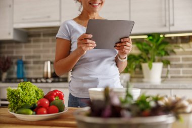 Güzel, hoş ve yakışıklı kadın evdeki mutfağında lezzetli, sağlıklı bir salata hazırlıyor.