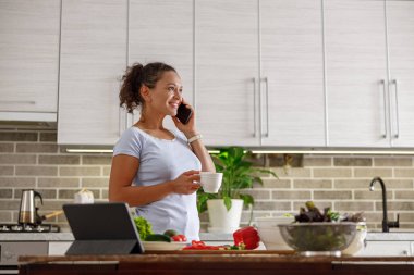 Güzel, hoş ve yakışıklı kadın evdeki mutfağında lezzetli, sağlıklı bir salata hazırlıyor.