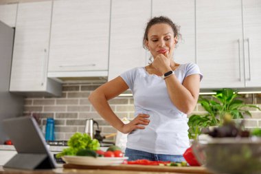 Güzel, hoş ve yakışıklı kadın evdeki mutfağında lezzetli, sağlıklı bir salata hazırlıyor.