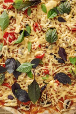 Güzel, hoş, yakışıklı bir kadın evdeki mutfağında sebzeli taze İtalyan pizzası hazırlıyor.