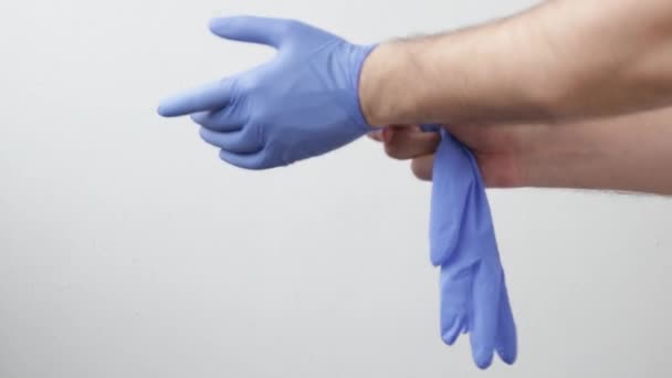 Nahaufnahme. Die Verwendung von Schutzhandschuhen für die Coronavirus-Pandemie, das Tragen von Ausrüstung während der Covid-19-Epidemie. Das Konzept von Schutz und Gesundheit. — Stockvideo