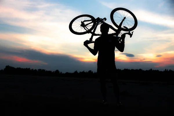 Силует Спортивного Чоловіка Стоїть Дії Піднімаючи Велосипед Над Головою Лузі — стокове фото