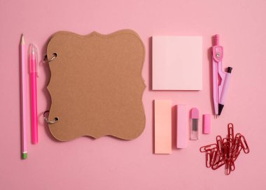 Boş defter sayfası renkli kalemler ile en iyi görünümü tablo. Düz yatıyordu. Okul malzemeleri, kalem, makas, silgi ve pembe bir arka plan üzerinde renkli kalemler.