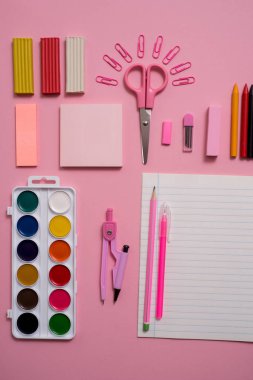 Sabit kavramı, düz yatıyordu yukarıdan Scissorsschool fotoğraf malzemeleri, Not defteri ve kalem, pembe bir arka plan üzerinde renkli kalemler. pembe arka plan kopya alanı ile.